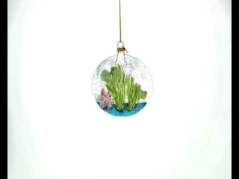 Adorno navideño de cristal con peces amarillos dentro de una pecera