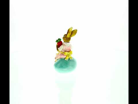 Springtime Serenity: Mother Bunny Cradling Carrot Atop a Decorative Easter Egg Figurine