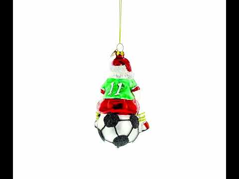 Adorno navideño de vidrio soplado con Papá Noel sentado sobre un balón de fútbol